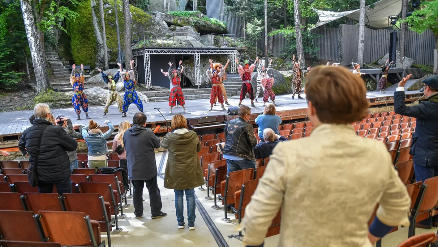 Personen schauen einer Probeaufführung zu